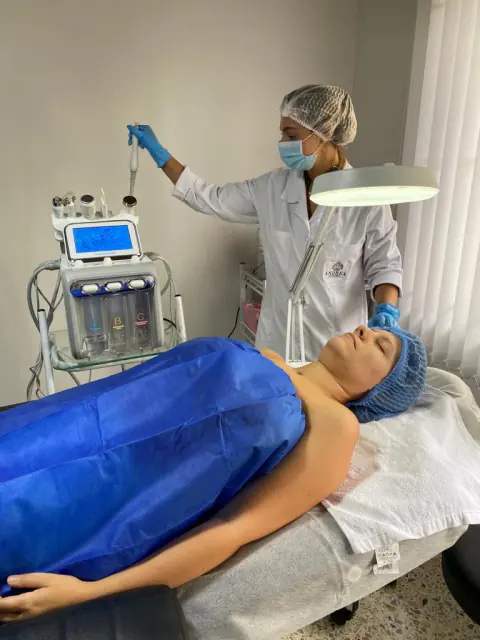 Esteticista con equipo de aparatología facial