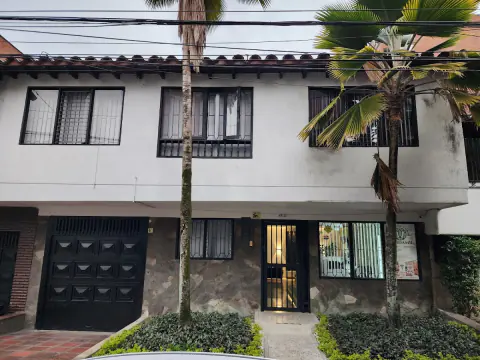 Casa blanca de Candamil en Los Conquistadores, con palmas al frente